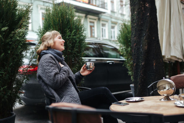 femme buvant un café sur une terrasse d'hiver